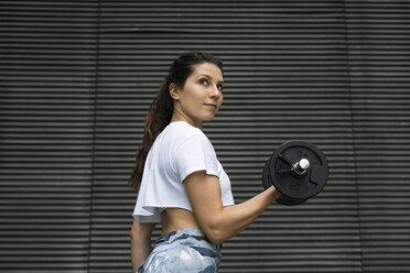 Junge Frau beim Krafttraining im Freien - FMGF00090