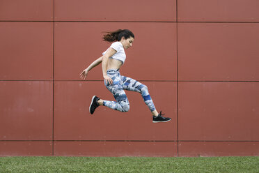 Fit young woman jumping midair - FMGF00095