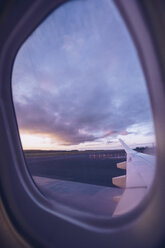 View of airplane wing through window at twilight - RSGF00048