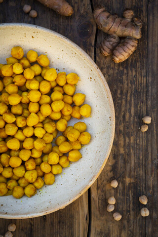 Schüssel mit gebratenen Kichererbsen, gewürzt mit Kurkuma, lizenzfreies Stockfoto