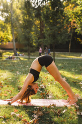 Fit junge Frau übt Yoga in einem Park - KKAF02930