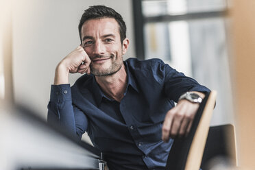 Mature man sitting in office, thinking, leaning head on hand - UUF15808