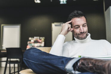 Businessman working relaxed in his office - UUF15831