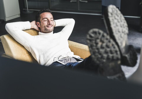 Geschäftsmann entspannt sich im Büro, lizenzfreies Stockfoto