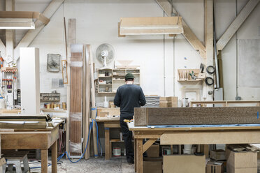 Tischler bei der Arbeit an einem Schrankprojekt an seinem Arbeitsplatz in einer Möbelfabrik. - MINF09119
