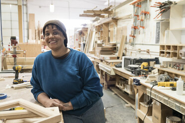 Porträt einer schwarzen Schreinerin in einer großen Holzwerkstatt. - MINF09134