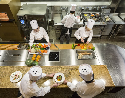 A view looking down on a crew of chefs working in a commercial kitchen, - MINF09218