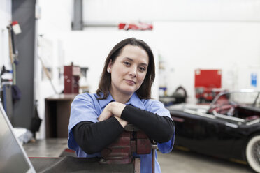 Ein Porträt einer kaukasischen Mechanikerin in einer Autowerkstatt. - MINF09230