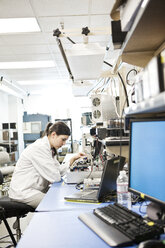 A Caucasian female technician working over a problem in a technical research and development site. - MINF09313