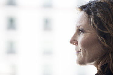 Caucasian business woman looking out the window of a conference centre lobby. - MINF09366