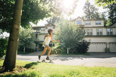 Tween Girl Skating auf Skateboard auf dem Bürgersteig in Wohngegend - MINF09418