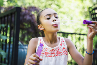 Tween Girl Blowing Bubbles in den Hinterhof - MINF09421