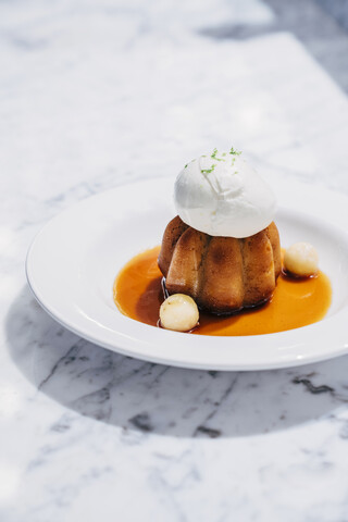 Rum-Baba-Torte mit Bananenkaramell und Limetteneis, lizenzfreies Stockfoto