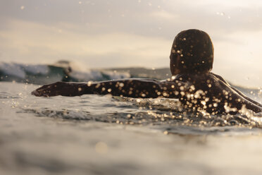 Mann surft auf dem Meer gegen bewölkten Himmel bei Sonnenuntergang - CAVF53349