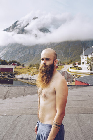 Norwegen, Lofoten, Porträt eines hemdlosen Mannes mit Vollbart, lizenzfreies Stockfoto