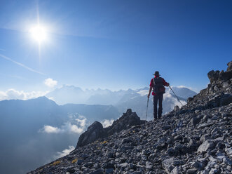 Border region Italy Switzerland, senior man hiking in mountain landscape at Piz Umbrail - LAF02145