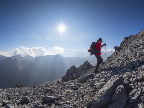 Grenzregion Italien Schweiz, älterer Mann beim Wandern in Berglandschaft am Piz Umbrail, lizenzfreies Stockfoto