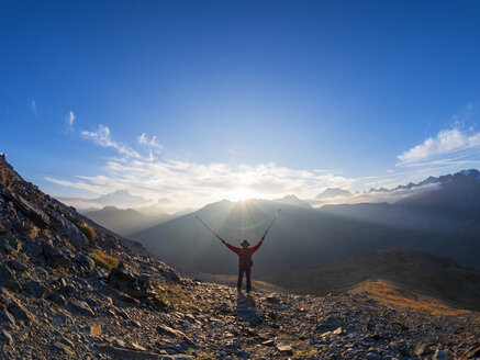 Grenzregion Italien Schweiz, jubelnder älterer Mann mit Wanderstöcken in Berglandschaft am Piz Umbrail - LAF02164