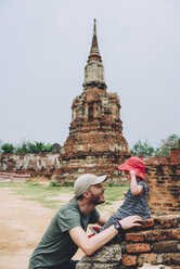 Thailand, Ayutthaya, Vater und kleines Mädchen in den alten Ruinen des Wat Mahathat Tempels - GEMF02471
