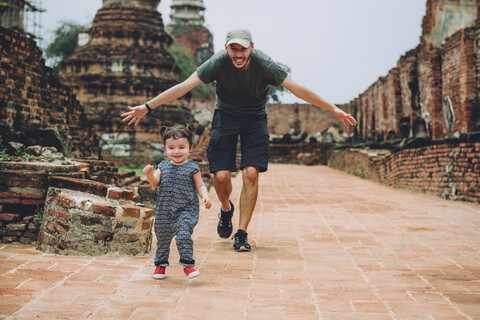 Thailand, Ayutthaya, Father and daughter running in the ancient ruins of a temple at Wat Mahathat stock photo