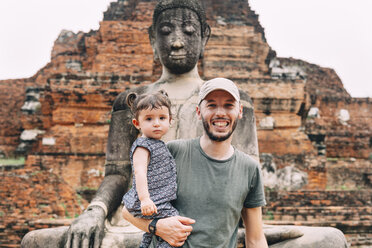 Thailand, Ayutthaya, Porträt eines lächelnden Vaters und einer lächelnden Tochter vor einer Buddha-Statue im Wat Mahathat - GEMF02474