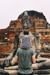 Thailand, Ayutthaya, Father and daughter looking at a Buddha statue at Wat Mahathat - GEMF02475