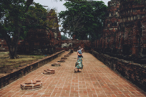 Thailand, Ayutthaya, Mutter und Tochter tanzen in den alten Ruinen eines Tempels im Wat Mahathat, lizenzfreies Stockfoto