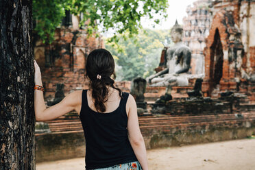 Thailand, Ayutthaya, Frau betrachtet eine Buddha-Statue im Wat Mahathat - GEMF02485