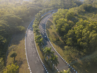 High angle view of road amidst trees during sunny day - CAVF53425