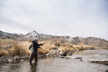 Man preparing fly fishing pole at sunny river - Stock Image - F033