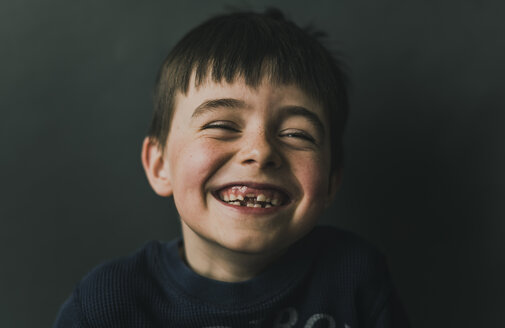 Porträt eines glücklichen Jungen, der an der Wand steht - CAVF53517