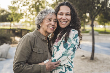 Portrait of happy daughter embracing senior mother at park - CAVF53548