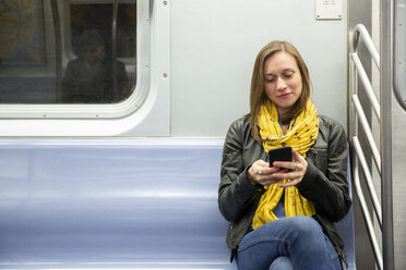 Frau benutzt Mobiltelefon während der Fahrt im Zug - CAVF53739