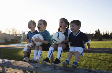 Children screaming while looking away at park against clear sky during sunset - CAVF53858