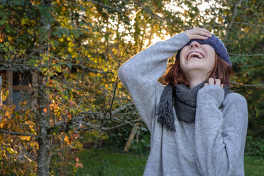 Laughing teenage girl wearing wooly hat and scarf in autumn - LBF02166