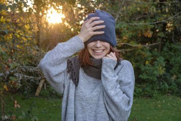 Laughing teenage girl wearing wooly hat and scarf in autumn - LBF02167