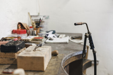 Nahaufnahme eines Schneidbrenners an einem Holztisch an der Wand in einer Werkstatt - CAVF53899