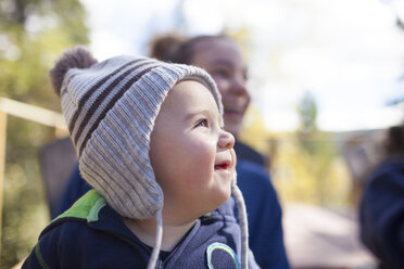 Nahaufnahme eines lächelnden kleinen Jungen mit Mutter im Hintergrund - CAVF54014