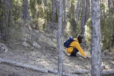 Junge Frau mit gelbem Pullover und blauer Tasche blau im Wald, auf Entdeckungstour - GRSF00001