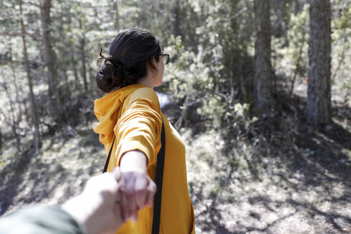 Junges Mädchen mit gelbem Pullover hält die Hand eines Mannes im Wald - GRSF00011