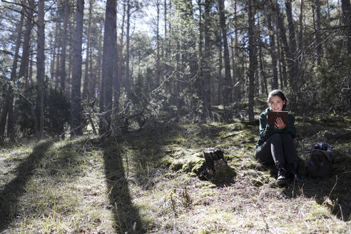 Junge Frau sitzt im Wald und schreibt - GRSF00012