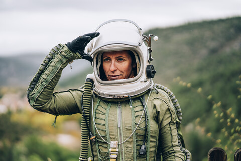 Porträt einer Frau im Raumanzug, die die Natur erkundet, lizenzfreies Stockfoto