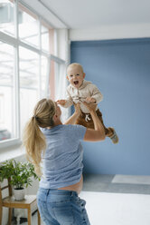 Pegnant mother lifting up happy toddler son - KNSF05221