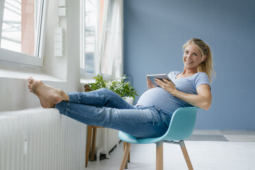 https://us.images.westend61.de/0001072892j/portrait-of-smiling-pregnant-woman-sitting-on-a-chair-at-the-window-holding-tablet-KNSF05251.jpg