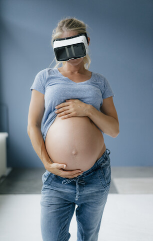 Schwangere Frau mit VR-Brille, lizenzfreies Stockfoto