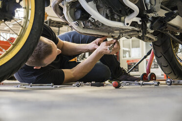 Mechaniker arbeitet an einem Motorrad in der Werkstatt - FBAF00158