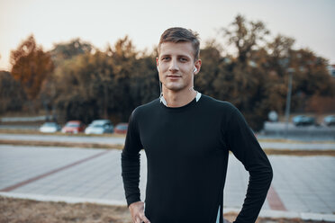 Portrait of confident sportive man outdoors in the evening - ZEDF01727