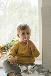 Portrait of little boy nibbling whipped cream - MOMF00539