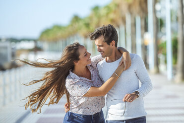 Happy young couple hugging on promenade - KIJF02070
