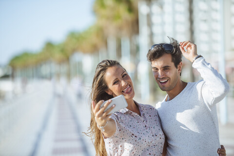 Glückliches junges Paar macht ein Selfie auf der Promenade, lizenzfreies Stockfoto